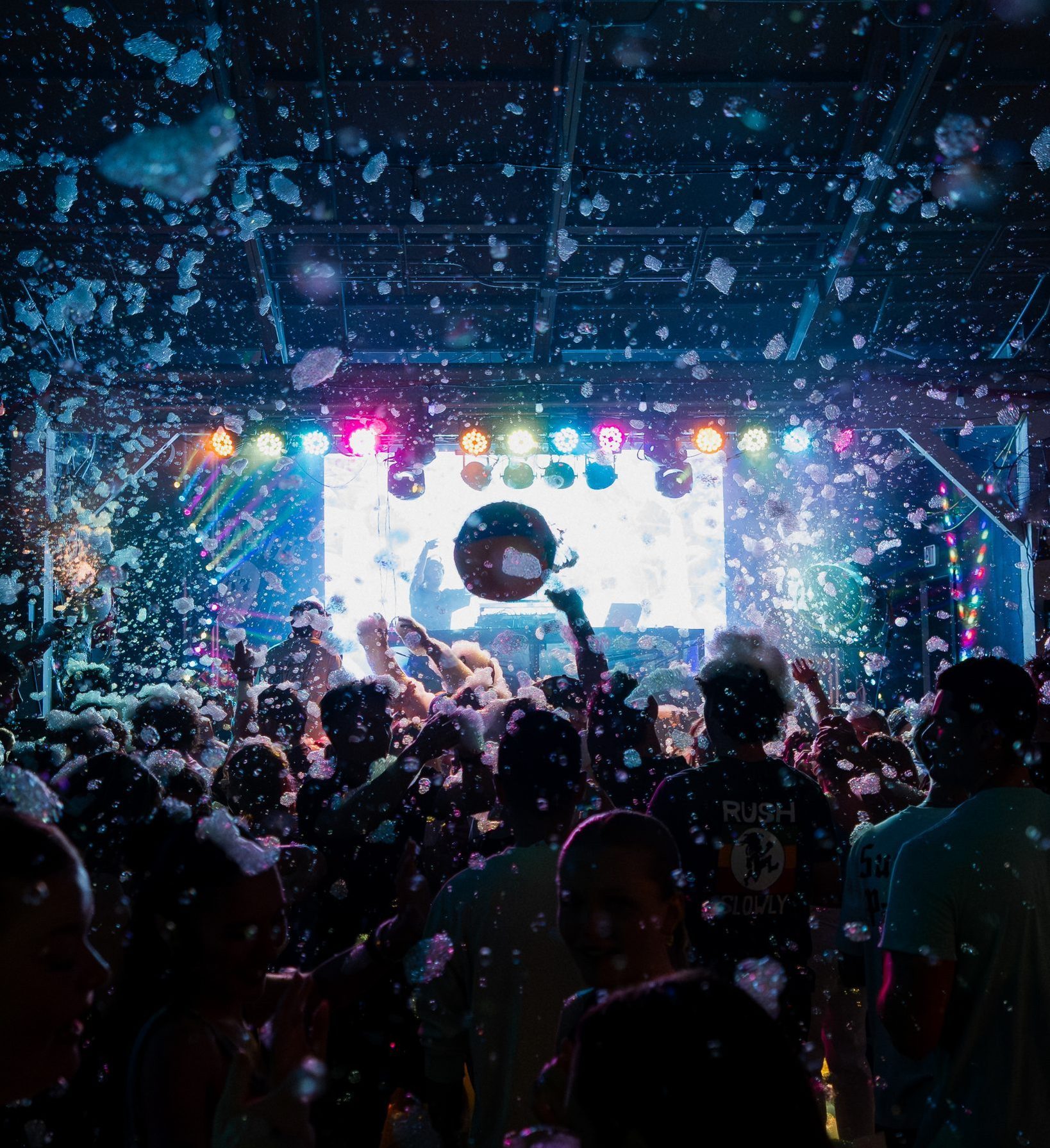 Crowd dancing under falling foam in front of the stage at the Hammerhead Fred's foam party, Panama City Beach