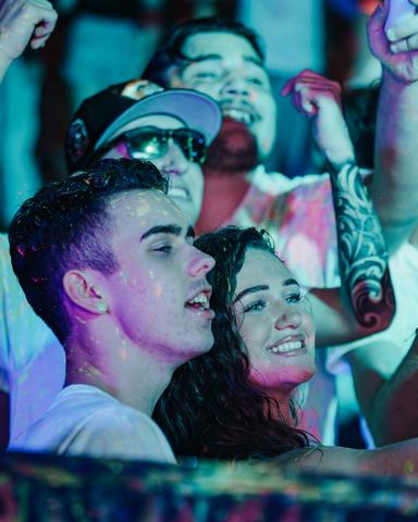 Couple Smiling Close Crowd Young couple smiling close together in a lively night crowd, Panama City Beach