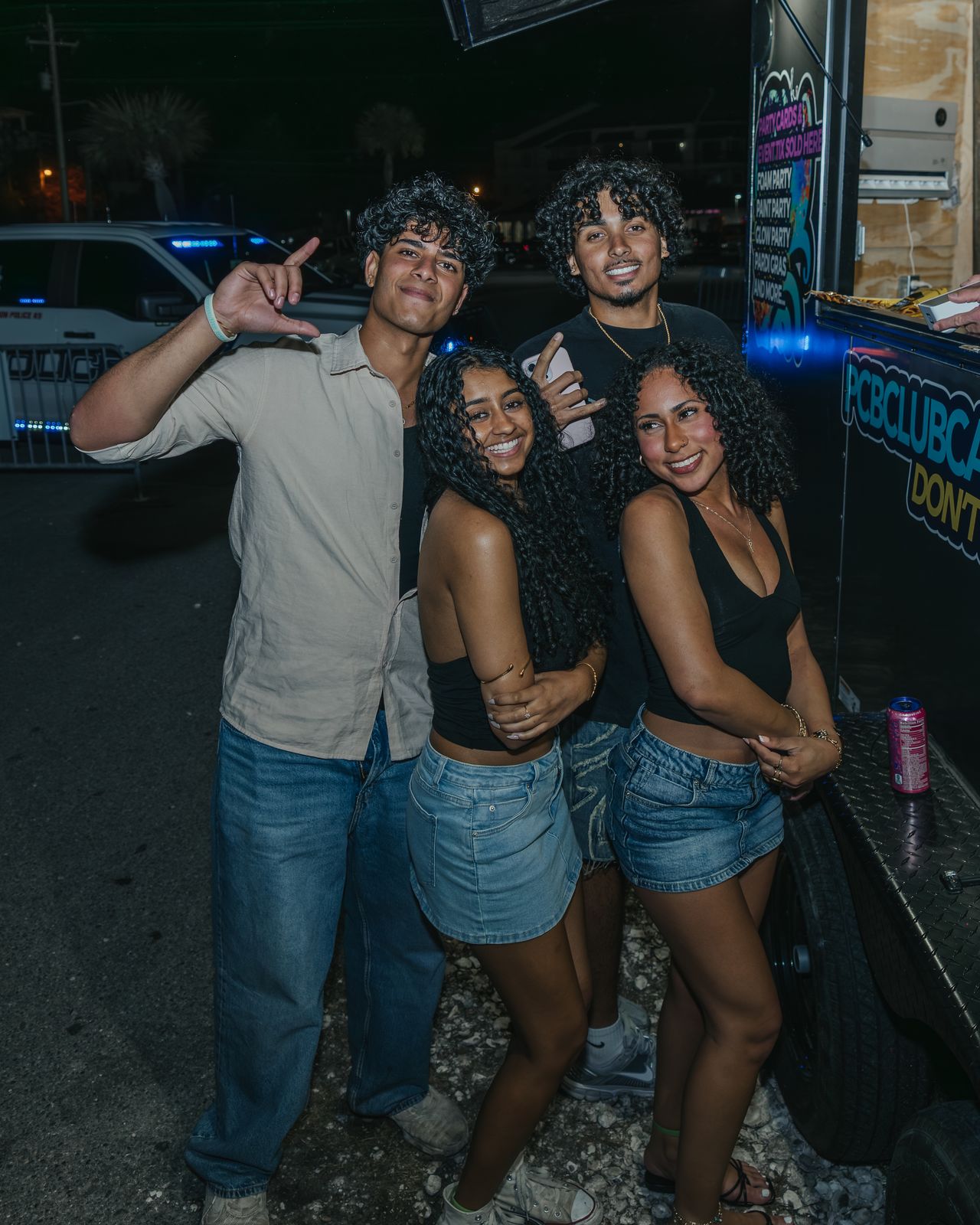 Three friends posing together outside a venue at night, Panama City Beach