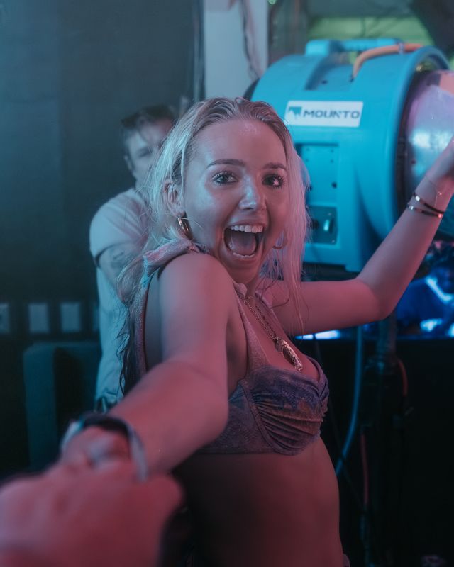 Woman laughing and reaching toward the camera at a night party, Panama City Beach