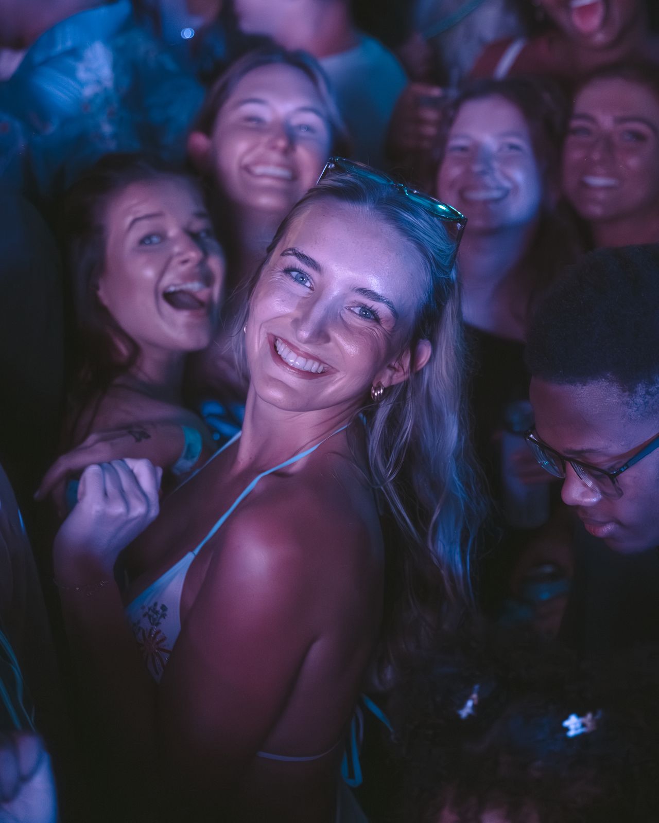 Woman Smiling Over Shoulder Friends Woman smiling over her shoulder with friends at a night party, Panama City Beach